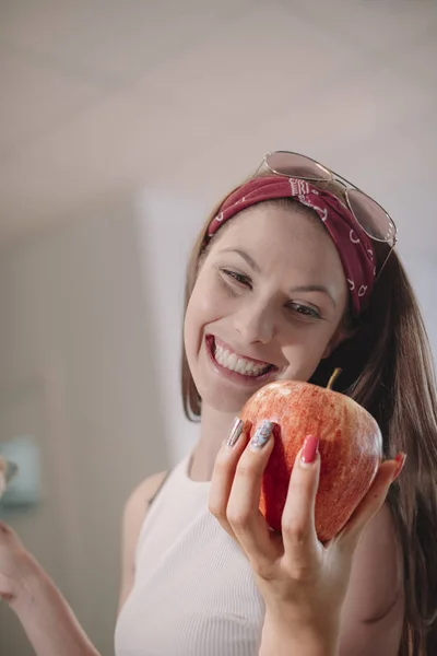 Beautiful model woman happy because she has a delicious red apple - Beautiful woman with sunglasses on her head - Freshly harvested apple