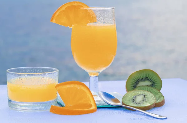 Orange juice and kiwi slices - Green kiwi with seeds - Ripe and sweet orange on a white table — Stock Photo, Image