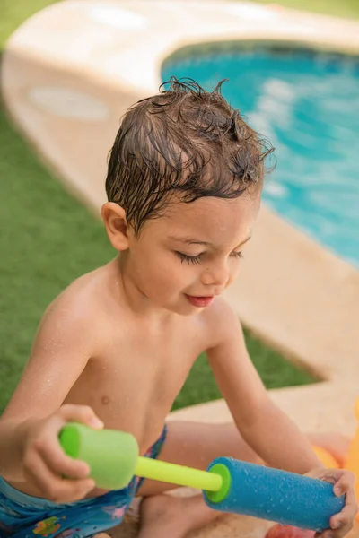 Bonheur visage d'un enfant jouant avec l'eau à côté de la piscine . — Photo