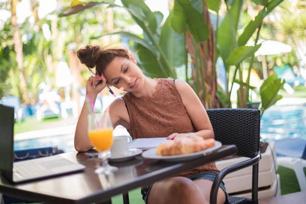 A beautiful woman writer having breakfast on a terrace