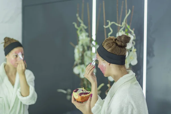Привлекательная белая девушка с каштановыми волосами, надевающая гранатовую маску на лицо - Organic Beauty Cosmetics — стоковое фото