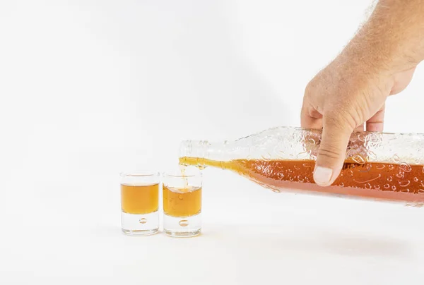 Detalj av en mans hand som serverar whisky i två små glas — Stockfoto