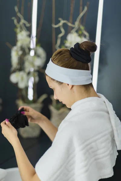 Vrouw in een spa zien een zwart masker-sierplanten op de achtergrond — Stockfoto