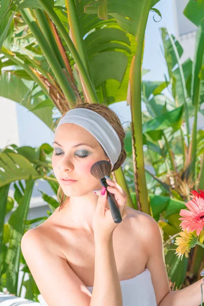 Jeune femme brune se maquillant au pinceau cosmétique — Photo