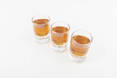 Lezzetli ve lüks viski üç bardak dizilmiş ve beyaz bir arka plan üzerinde izole servis