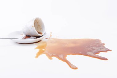 Beyaz bir arka plan üzerine dökülen kahve bir fincan