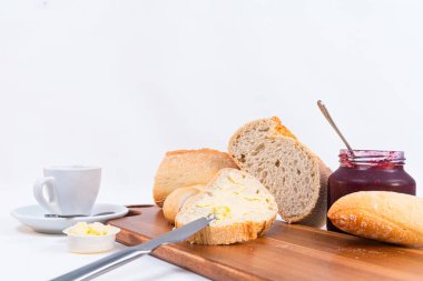 rustik ahşap masada ev yapımı reçel çekim ile tereyağı ve kavanoz ile tahıl ekmek dilimleri. Beyaz arka plan.