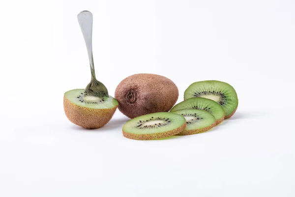 Delicioso lanche kiwi fresco - Um kiwi inteiro, um corte ao meio com uma colher e fatias de kiwi verde com semente — Fotografia de Stock