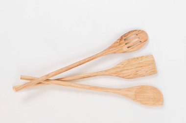 Beyaz bir arka plan üzerinde üç güzel ahşap mutfak kepçeler.