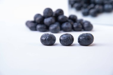 Arka planda tatlı ve olgun yaban mersini Grubu - Beyaz bir masada lezzetli ıslak yaban mersini - Close-up