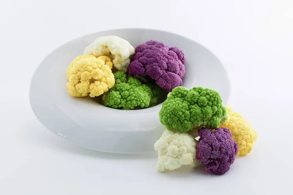 Coliflores de color servidas en un plato blanco. Púrpura, blanco, ye —  Fotos de Stock