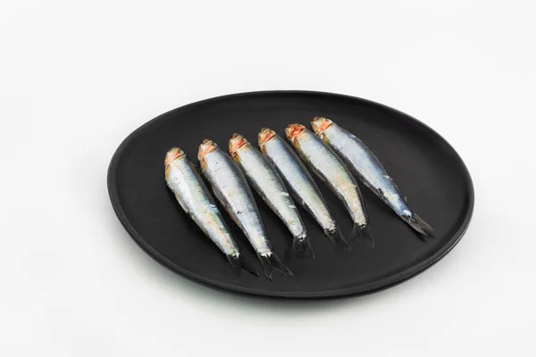 흰색 배경에 검은 접시에 여섯 신선한 정어리. 콘세이스 (콘세이 — 스톡 사진
