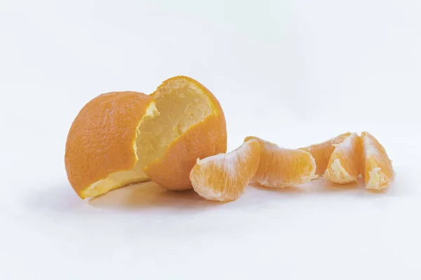 Cáscara de naranja y rebanadas sobre un fondo blanco - Snack naranja dulce — Foto de Stock