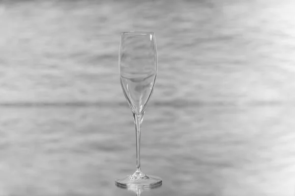 Detalle fotográfico de una elegante taza de vidrio sobre una mesa de vidrio y un fondo de lo brillante fuera de foco . — Foto de Stock