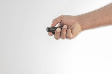 Beyaz arka plan daki bir arabanın kablosuz kontrolünün düğmelerinden birine basan bir el. Yazılabilmek için alan.