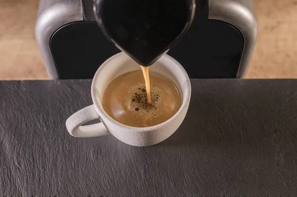 Draufsicht auf eine Kaffeemaschine mit weißer Kaffeetasse darunter — Stockfoto