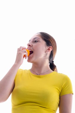 Sağlıklı görünümlü genç bir kadın arka planda lezzetli bir kayısı ısırıyor. Sağlıklı gıda ve yaşam tarzı konsepti.