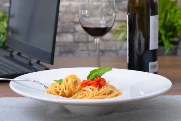와인과 노트북이 있는 맛있는 스파게티 요리 — 스톡 사진
