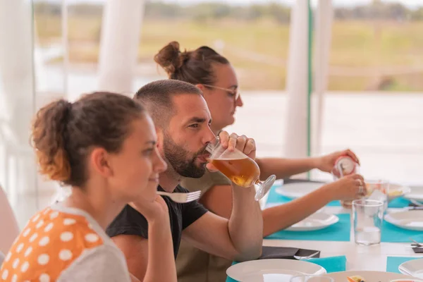 Hombre Guapo Bebiendo Vaso Cerveza Mientras Está Rodeado Mujeres Sentadas —  Fotos de Stock