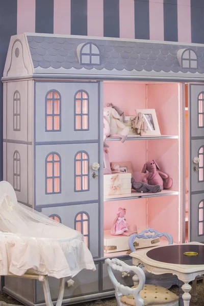 A children\'s girl\'s cute cupboard with shelves in the form of a doll\'s house. Interior of a children\'s room for a little princess girl.