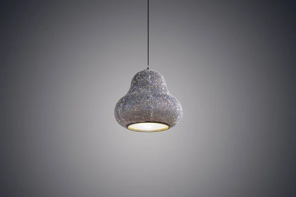 Pendant lamp, chandelier pasted precious stones, crystals, jewels. Glamorous fashionable pendant lamp isolated on a gray background.