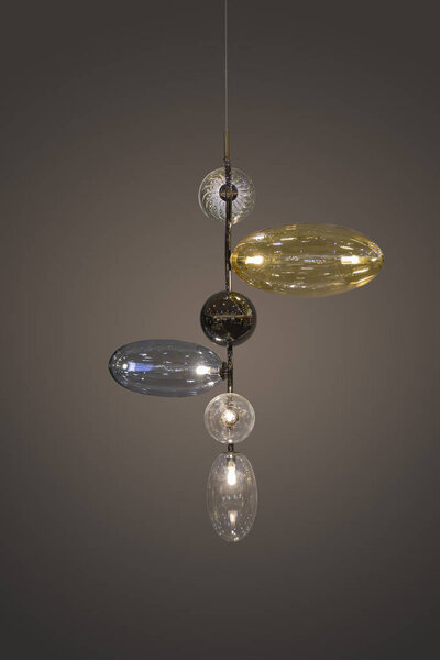 Beautiful glass geometric modern ceiling lamp interior contemporary decoration isolated on a dark background. Lamp in the form of glass oval spheres.