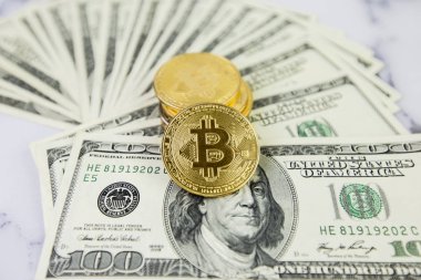 Altın sikke bitcoin yüz dolar faturaları bir yığın üzerinde yatıyor. Kripto para birimi, fiziksel para. Bir dolar için Exchange bitcoin. Dünya çapında cryptocurrency ve dijital ödeme sistemi için kavramsal görüntü.