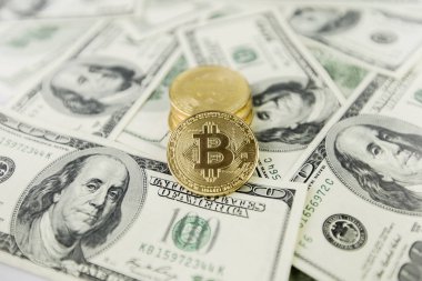 Altın sikke bitcoin yüz dolar faturaları bir yığın üzerinde yatıyor. Kripto para birimi, fiziksel para. Bir dolar için Exchange bitcoin. Dünya çapında cryptocurrency ve dijital ödeme sistemi için kavramsal görüntü.