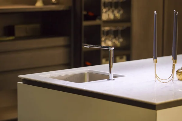 Modern kitchen, the water tap and kitchen sink. Kitchen island with a tap and marble white worktop