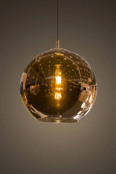 Modern streamlined mirror round copper chandelier. Bubble glass transparent pendant light. Isolate on dark background Royalty Free Stock Photos