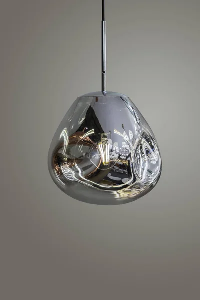 Lustre moderne argenté miroir rationalisé. Lampe suspendue en forme de métal forme intéressante isolée sur fond gris. Style loft — Photo