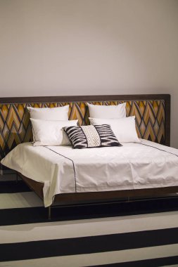 Modern şık yatak odası, Art Nouveau tarzında başlık ile çift kişilik yatak, retro, bir zikzak desenli, çatı yatak odası