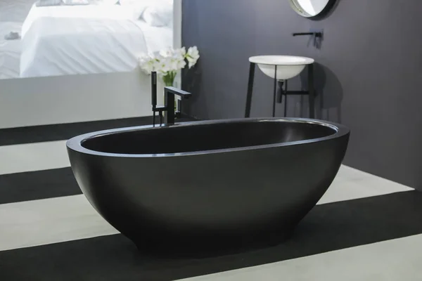 独立式黑色浴缸，时尚的简约黑白阁楼式浴室。浴室、洗脸台、墙上的镜子 — 图库照片