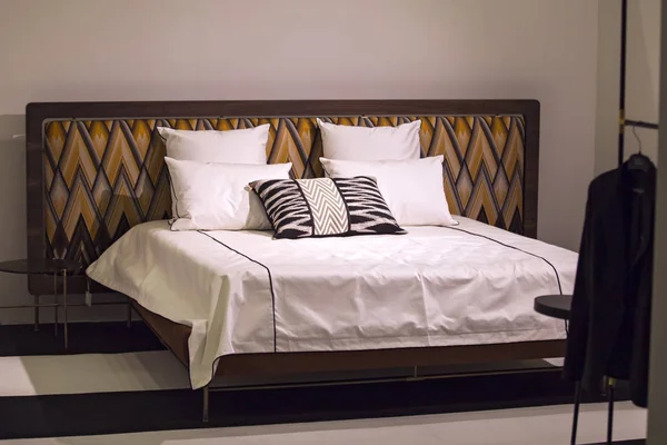 Современная стильная спальня, двуспальная кровать с подголовником в стиле ар-нуво, ретро, с загогулиновым узором, лофт-спальня — стоковое фото