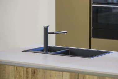 Modern mutfak, siyah su musluğu ve mutfak lavabosu. Bir musluk ve gri tezgah ile Mutfak adası