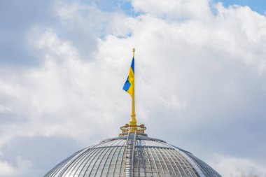 Binanın kubbesinde Ukrayna bayrağı. Bulutlarla gökyüzünün arka planında sarı-mavi bayrak