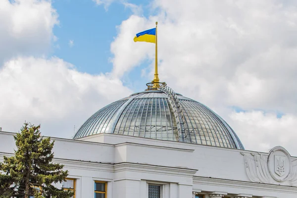 Прапор України на куполі будівлі парламенту. Жовто-блакитний прапор на тлі неба з хмарами. — стокове фото