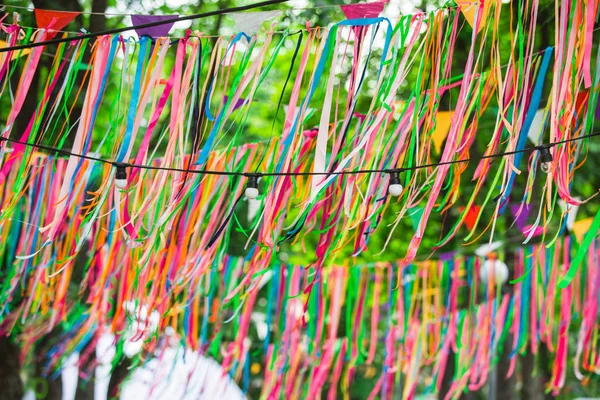 Fitas de cetim cor festiva decorando a rua. Casamento decoração festiva, fitas penduradas nas árvores no parque — Fotografia de Stock