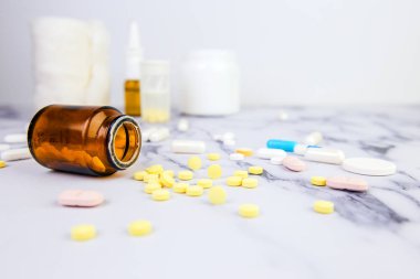 Beyaz mermer arka plan üzerinde farklı renk ve boyutlarda hap ve ilaç ile Kavanoz. Tıbbi tema