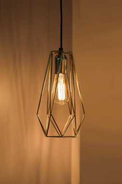 Kolye lambası geometrik şekilli abajur, altın metal avize. Çatı katı tasarımı