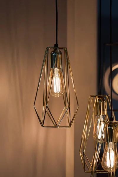 Lampadari poligonali. Concetto interno alla moda. Lampada a sospensione forma geometrica paralume, lampadario in metallo dorato — Foto Stock