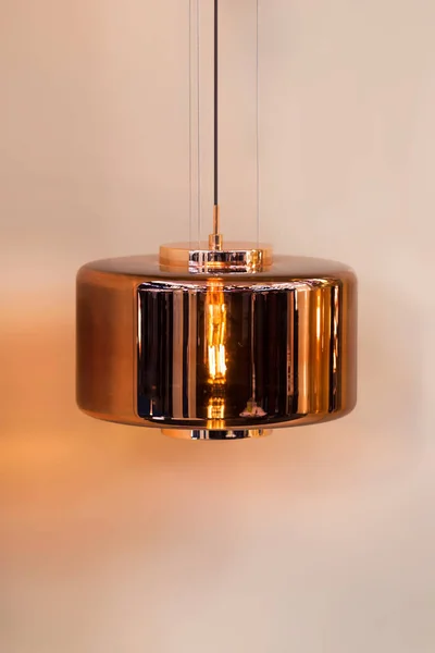 Moderne gestroomlijnde spiegel koperen kroonluchter. Metaalvormige hanglamp interessante vorm geïsoleerd. Loft stijl — Stockfoto