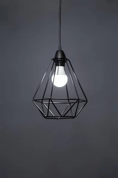Polygonální lustr. Přívěšek geometrický tvar stínítka lampy, černý kovový lustr. Izolováno na šedém pozadí — Stock fotografie