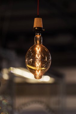 Koyu arkaplanda klasik akkor Edison tipi ampul. Sıra dışı şekil tasarımlı ampul