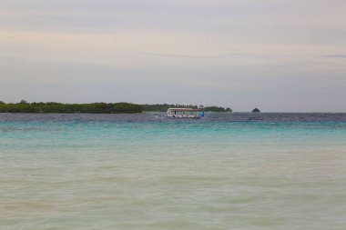 Renkli Hint Okyanusu, Maldivler muhteşem manzarası. Adanın kıyısında geçen küçük taşıma tekne. 