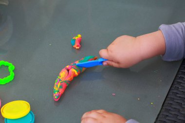 Çocuğun elleri renkli hamuru ile oynamak. Çocukluk kavramı. Çocuk arka plan.