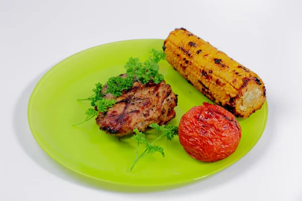 Close up view of grilled stake, tomato and corn on green plate. Food concept. Healthy food. Healthy lifestyle.