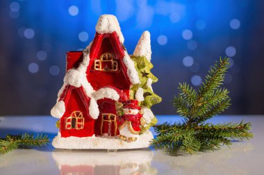 Noel ağacına mavi parlak renkli dekoratif sevimli kırmızı ev. Yılbaşı / yeni yıl güzel arka planlar.