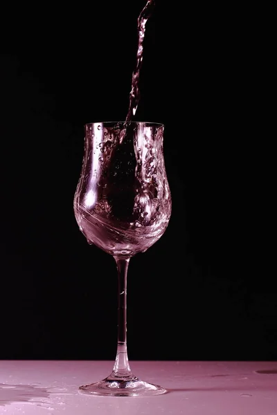 Закройте Вид Плещущую Воду Стекле Изолированном Розовым Красивый Фон — стоковое фото
