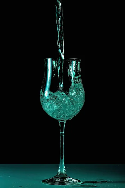 分離したガラス中の水のしぶきのビューを閉じます エメラルド色の美しい背景 — ストック写真